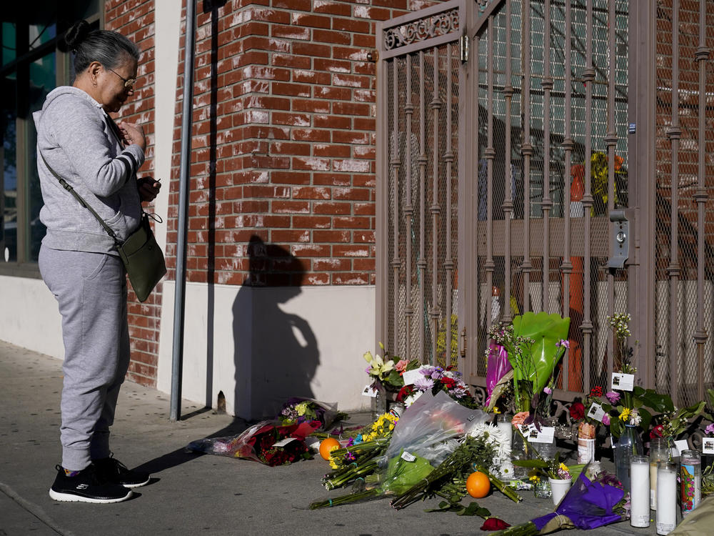 Eleven people were killed and nine more were injured at a dance studio near a Lunar New Year celebration on Saturday night. Here, a woman is seen praying for victims outside Star Dance Studio in Monterey Park, Calif., on Monday.