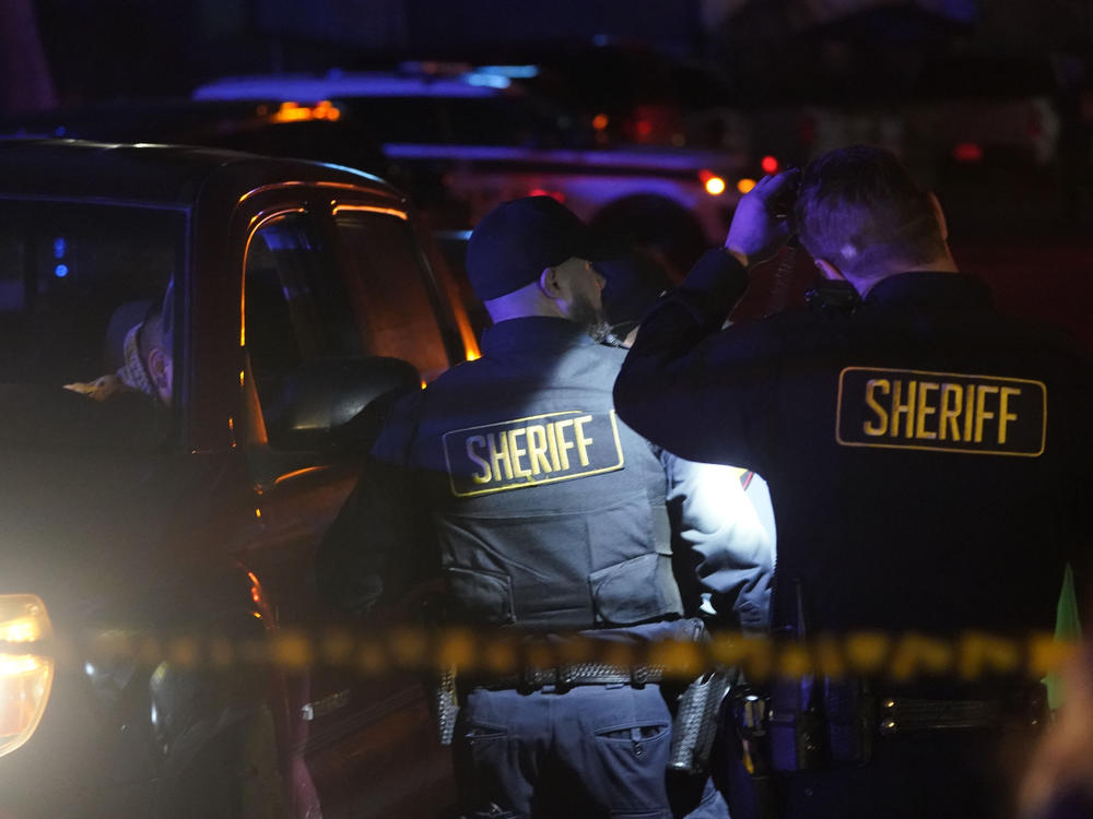 Law enforcement personnel stand at the scene of a shooting on Monday in Half Moon Bay, Calif. Seven people were killed in two related shootings.