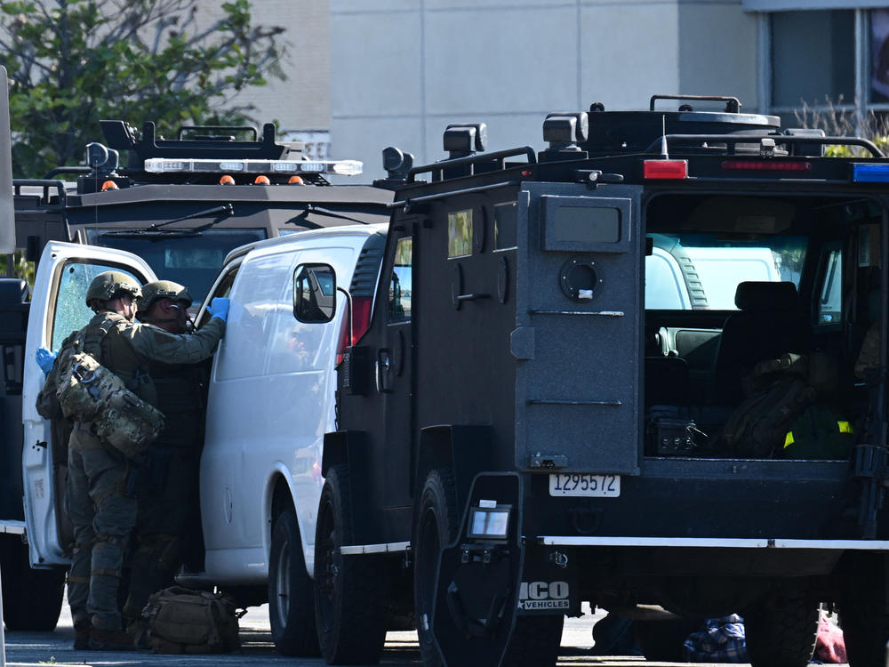 Law enforcement personnel open the door of a van outside the site in Torrance, Calif., where the suspect in the mass shooting in Monterey Park took his own life.