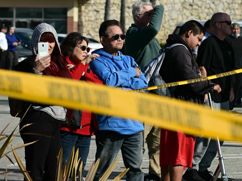 Bystanders watch law enforcement agents breaking into a van containing the suspect's body in Torrance, California, on Sunday.