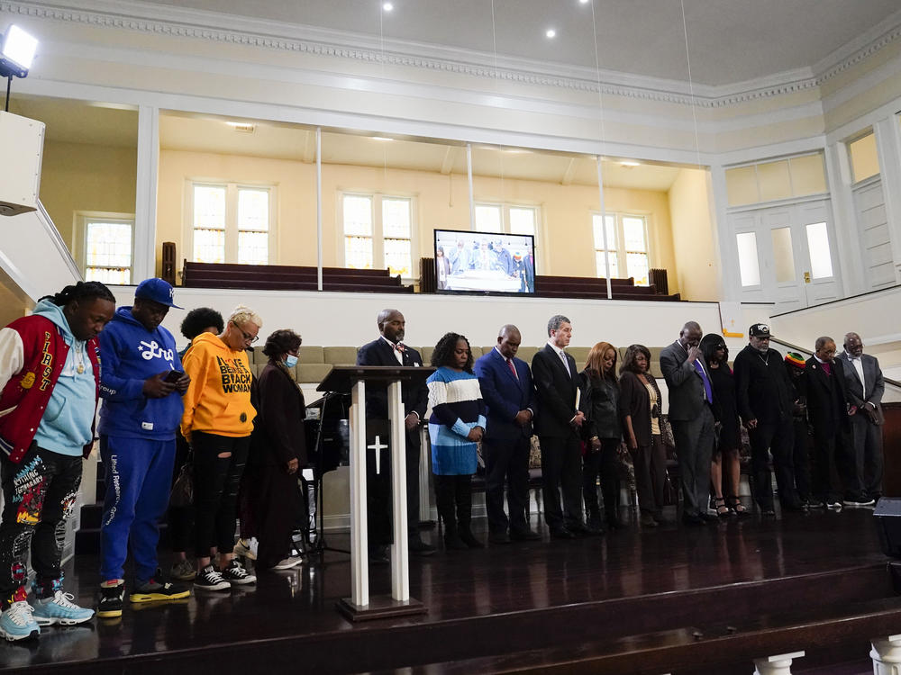 Family and supporters of Tyre Nichols, who died after being beaten by Memphis police officers, bow in prayer at the start of a news conference with civil rights Attorney Ben Crump in Memphis, Tenn., Monday, Jan. 23, 2023.
