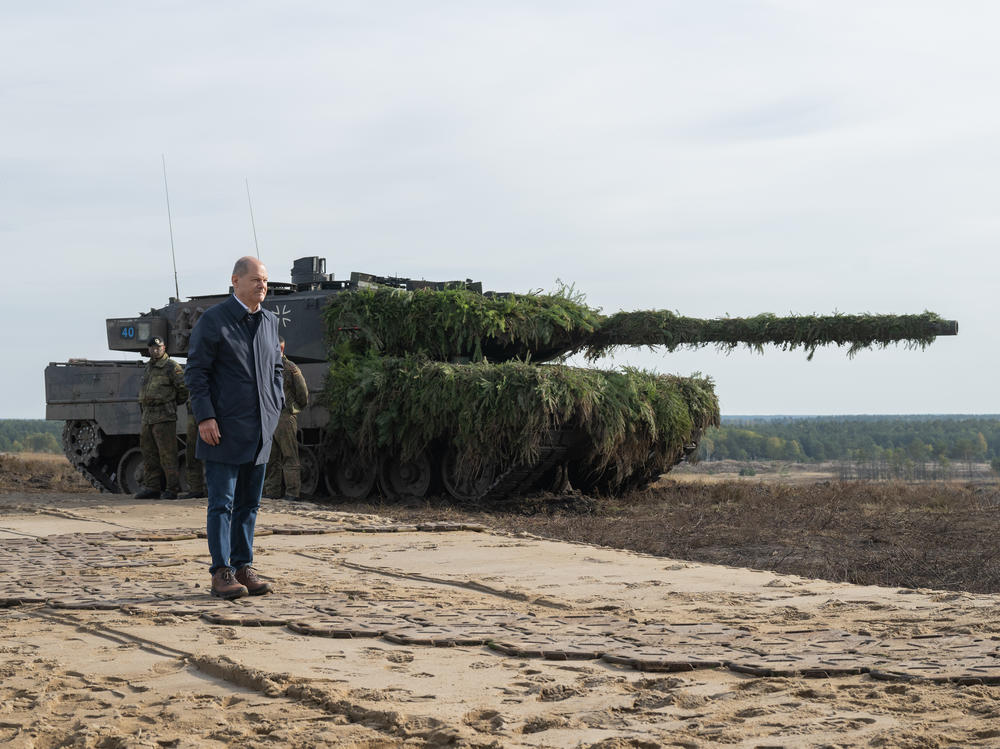 German Chancellor Olaf Scholz stands next to a Leopard 2 main battle tank of the German armed forces while visiting an army training center in Ostenholz, Germany, on Oct. 17, 2022.