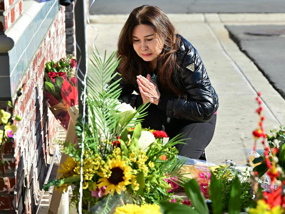 A woman who lost many friends in the Jan. 21 shooting in Monterey Park, Calif., grieves at a makeshift memorial outside the Star Ballroom Dance Studio.