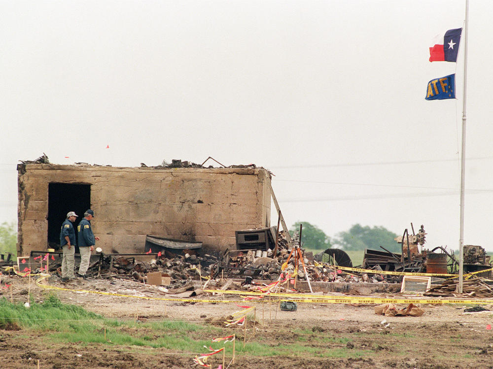 The Texas and the ATF flags fly at half staff April 23, 1993, over the only structure left standing after a fire destroyed the the Branch Davidian compound in Waco, Texas on April 19.