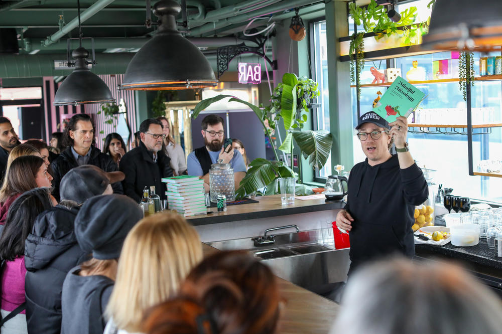 Derek Brown holds a copy of his book, <em>Mindful Mixology</em>, as he gives an overview of cocktail history at the Mindful Drinking Fest.