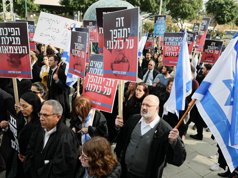 Lawyers gather in a demonstration against the Israeli government's controversial plans to overhaul the judicial system, outside the Tel Aviv District Court of Justice on Jan. 12. The new justice minister Yariv Levin outlined proposals such as allowing politicians to override Supreme Court decisions.