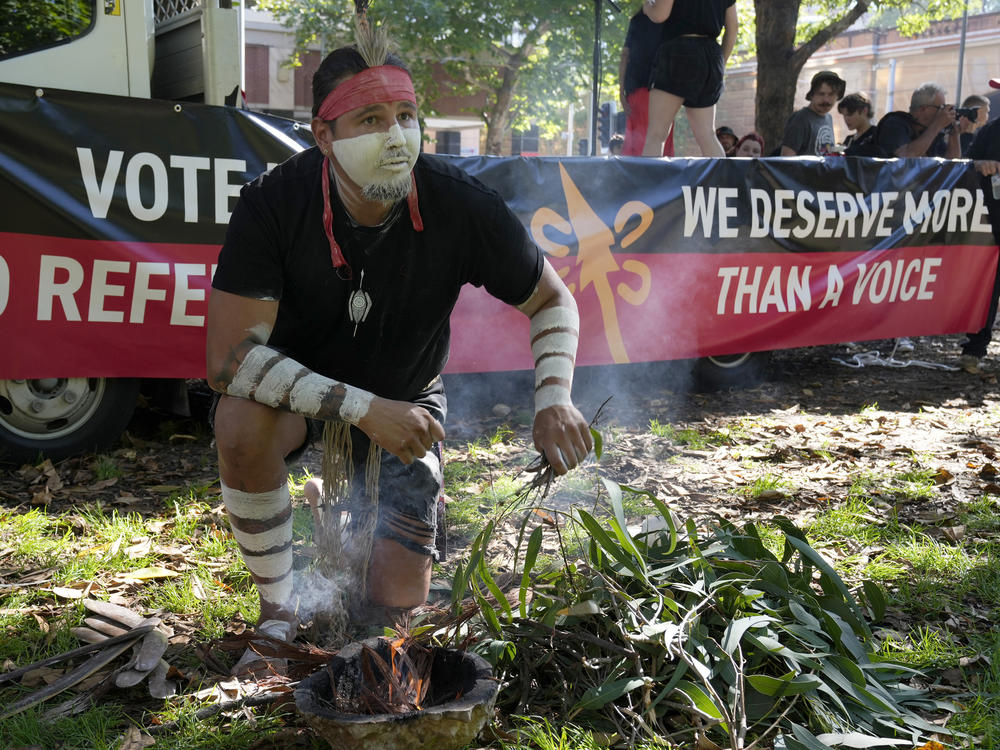 Aboriginal man Josh Sly of the Muggera Dancers prepares a fire for a smoking ceremony at the start of an Invasion Day rally in Sydney, Thursday, Jan. 26, 2023.
