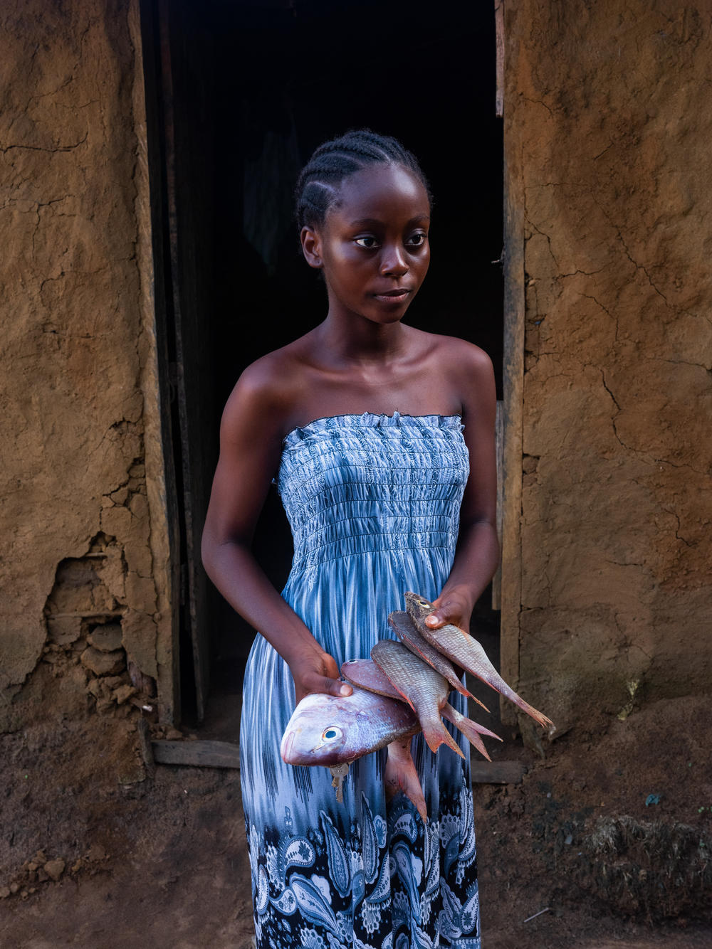 Maimouna brings back fish to cook for dinner in Barconie, Liberia, on Nov. 16, 2022.