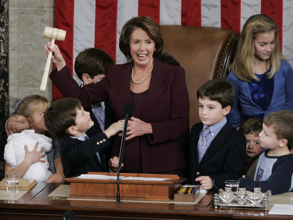 A newly elected Speaker of the House Nancy Pelosi holds up the gavel surrounded by children and grandchildren of members of Congress in the U.S. Capitol in 2007.