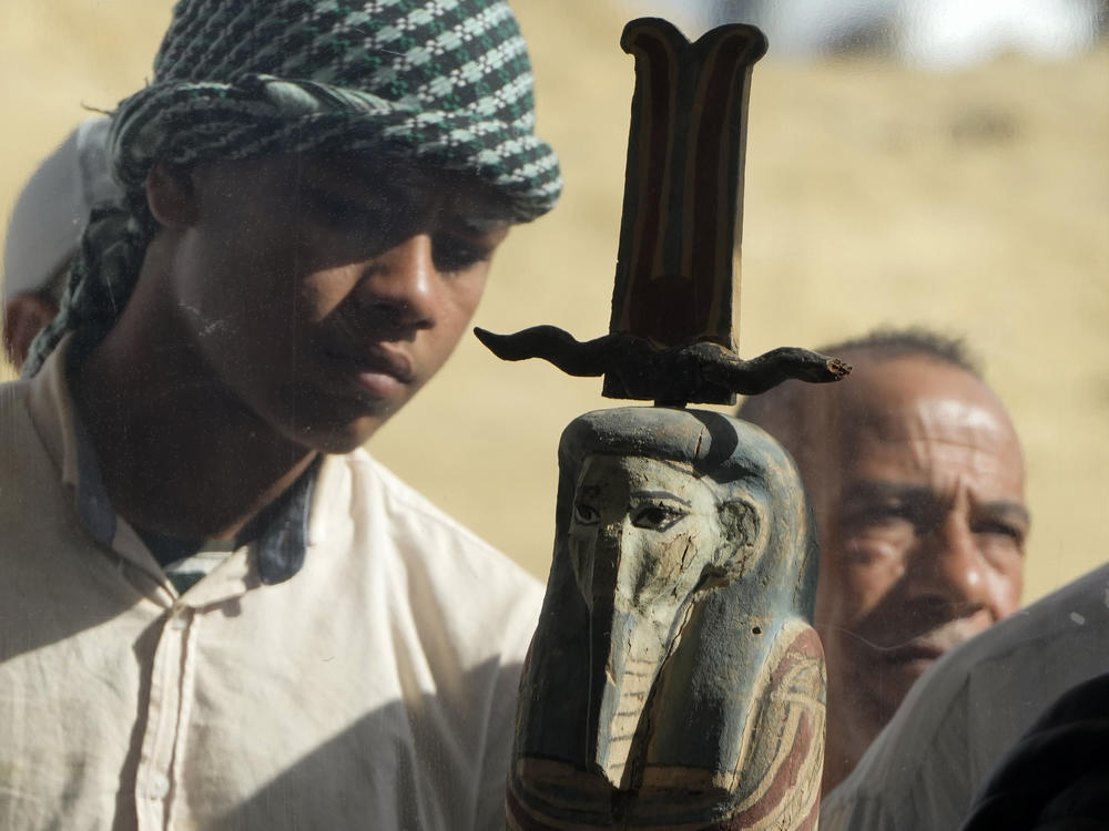 An Egyptian antiquities worker watches a recently discovered artifact at the site of the Step Pyramid of Djoser in Saqqara, 24 kilometers (15 miles) southwest of Cairo, Egypt, Thursday, Jan. 26, 2023.