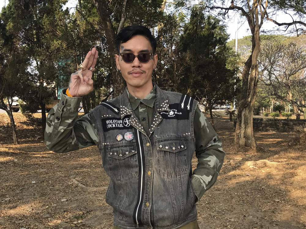 Political activist Mongkhon Thirakot flashes the pro-democracy gesture of a three-finger salute ahead of going to a court in Thailand's northern province of Chiang Rai, Thailand, Thursday Jan. 26, 2023.