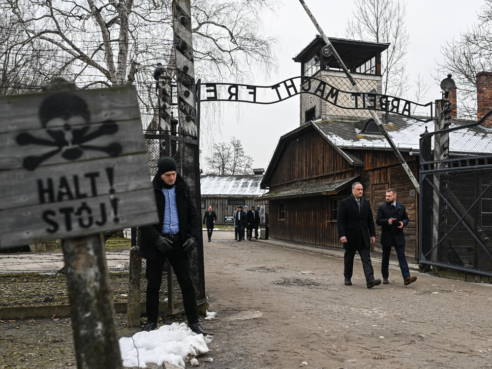 Emhoff (second right) walks past the main gate of the former Auschwitz Concentration Camp during his tour on Friday, International Holocaust Remembrance Day.