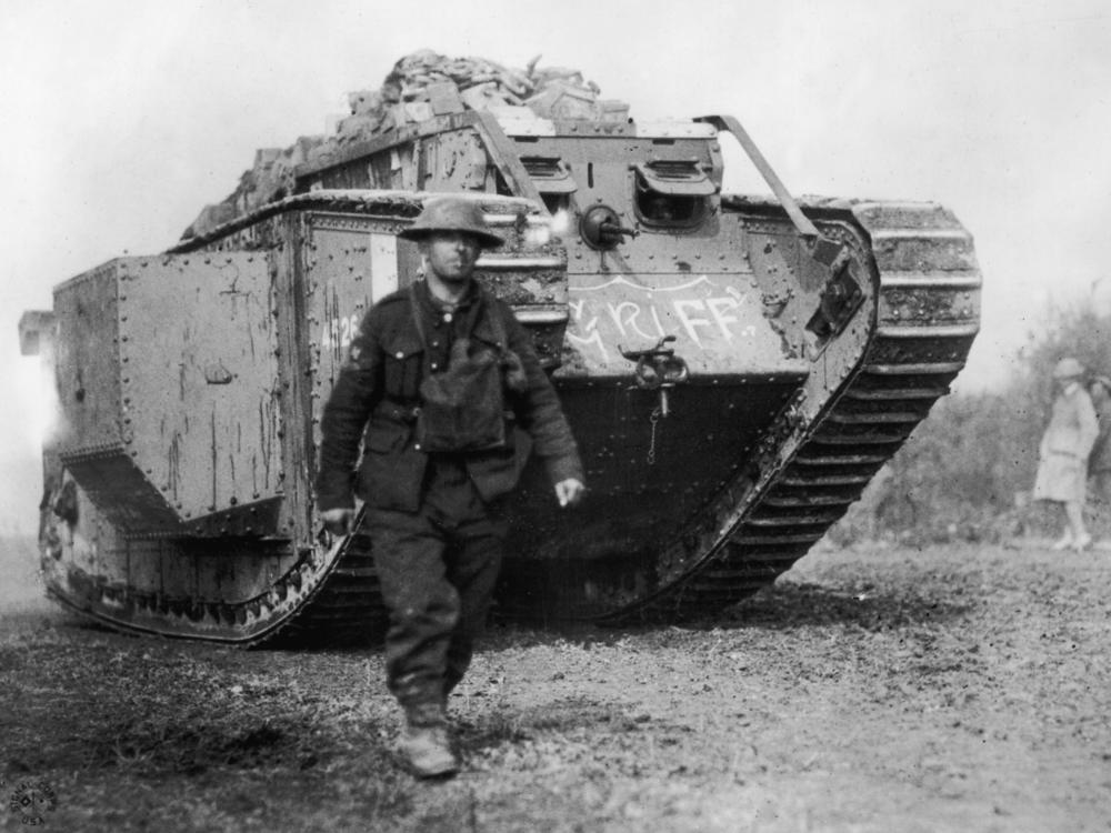 An American soldier walks ahead of an MKIV British-made tank, circa 1918.