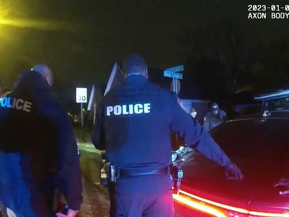 Police officers, who were seen on camera beating and kicking Tyre Nichols, stand by where Nichols is slumped over on the ground. This image is a screenshot of one of the videos from graphic police body camera footage released to the public on Friday night.