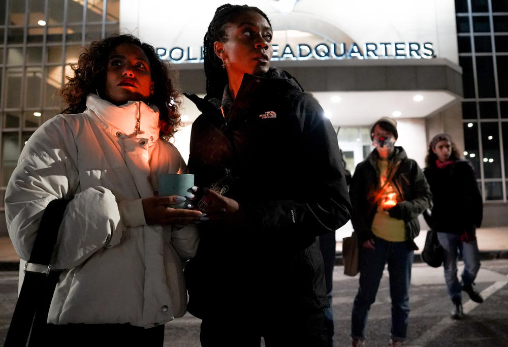 Hannah De Oliveira (left) and Cami Thomas hold a candle on Friday night during a vigil for Tyre Nichols outside of the St. Louis Metropolitan Police Department.