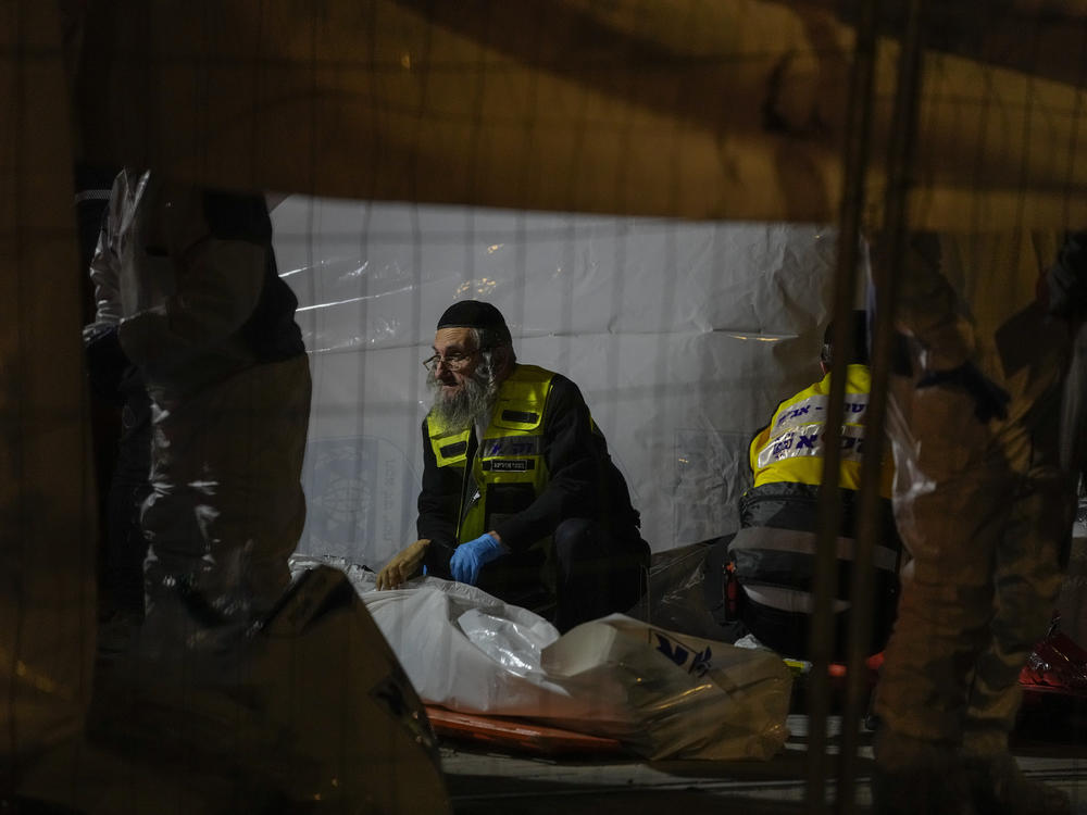 Members of Zaka Rescue and Recovery team check victims of a shooting attack that killed seven people  and wounded three near a synagogue in Jerusalem on Friday.