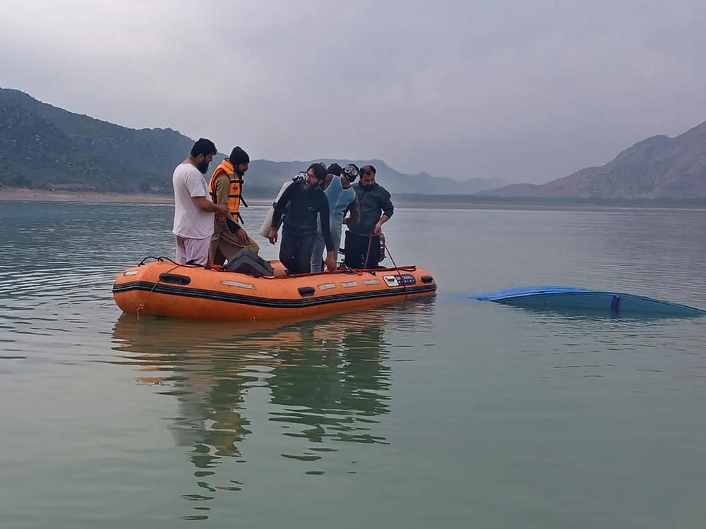 In this photo provided by Khyber Pakhtunkhwa's provincial rescue department, rescue workers search for bodies following a boat capsizing in Tanda lake, in Kohat, in northwest Pakistan, on Sunday.