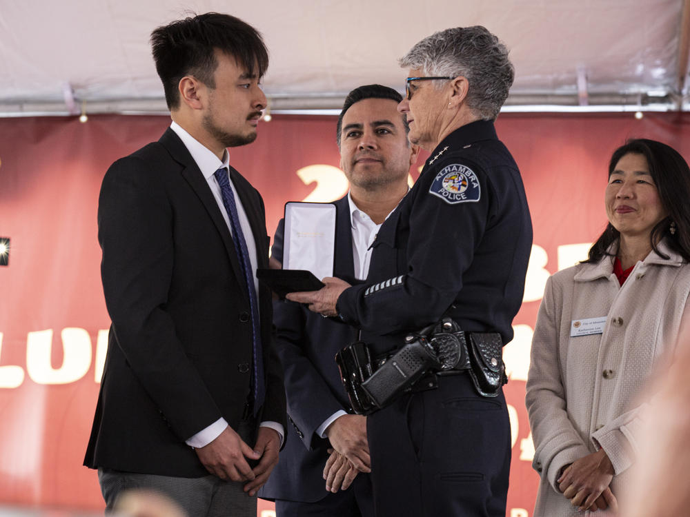 Brandon Tsay is awarded the medal of courage by Alhambra Police Chief Kelley Fraser at the Alhambra Lunar New Year Festival in Alhambra, Calif., on Sunday, a little over a week after the Monterey Park mass shooting.