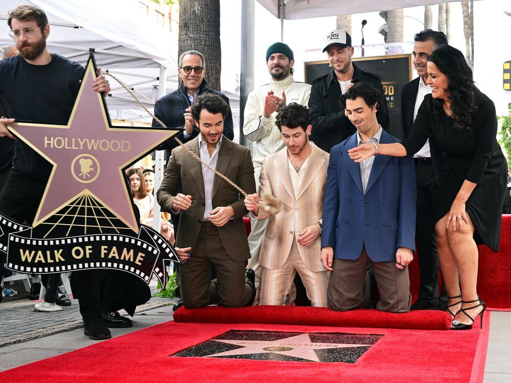 The Jonas Brothers react as their Hollywood Walk of Fame Star is unveiled during a ceremony on Monday in Hollywood, Calif. At the ceremony, they announced their sixth album will be released on May 5.