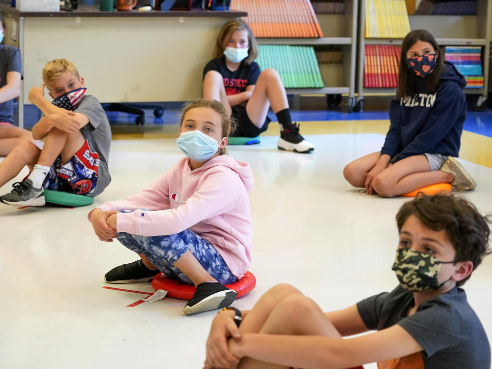 Fifth-graders wearing face masks sit at proper social distancing during a music class at the Milton Elementary School in Rye, N.Y., May 18, 2021. The COVID-19 pandemic that shuttered classrooms set back learning in some U.S. school systems by more than a year, with children in high-poverty areas affected the most, according to data shared with The Associated Press.