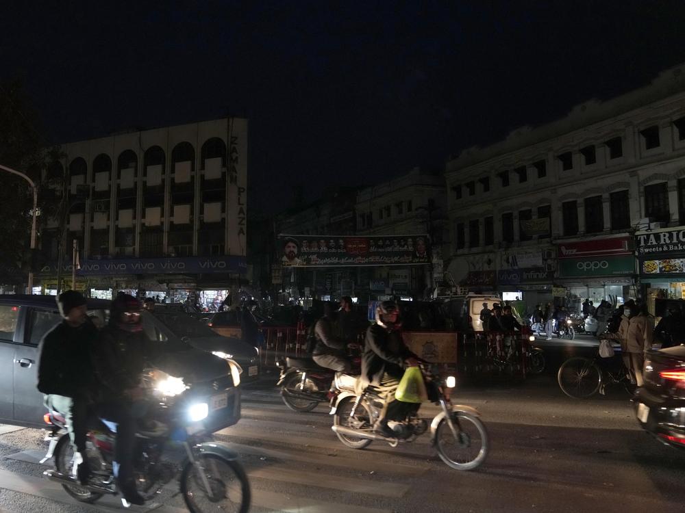 Vehicles drive through a market where some shopkeepers use generators for electricity during a national power breakdown, in Lahore, Pakistan, Jan. 23. Much of Pakistan was left without power that day.