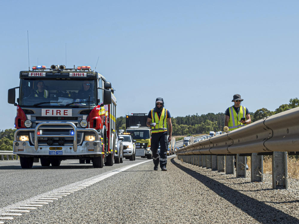 In this photo provided by the Department of Fire and Emergency Services, its members search for a radioactive capsule believed to have fallen off a truck being transported on a freight route on the outskirts of Perth, Australia, on Saturday.