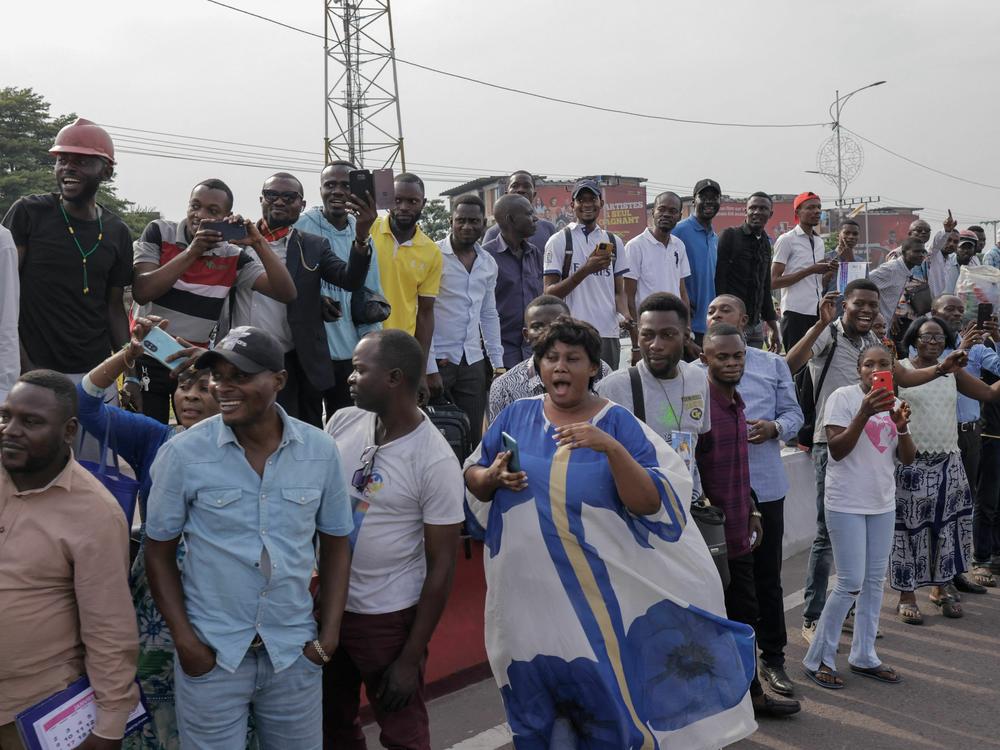 People gather on the side of the road to get a glimpse of Pope Francis as he departs the N'djili International Airport in Kinshasa.