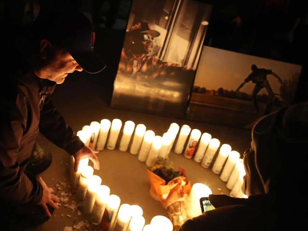 A mourner sits next to a candle display during a vigil for Tyre Nichols on Jan. 30 at Regency Community Skatepark in Sacramento, Calif. Nichols was an avid skateboarder and used to frequent the park.