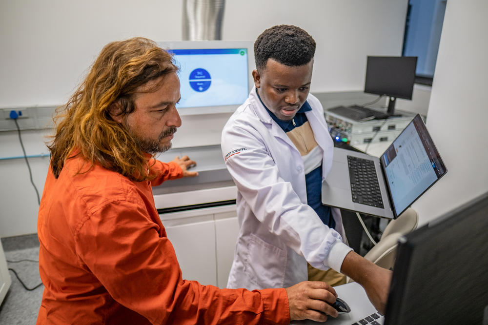 Tulio de Oliveira collaborates on a project with fellow scientist Wonderful Choga, who is visiting from Botswana. The center he directs in Cape Town has become a hub for researchers from across the Global South to develop even more advanced processes for determining the genetic code of pathogens.
