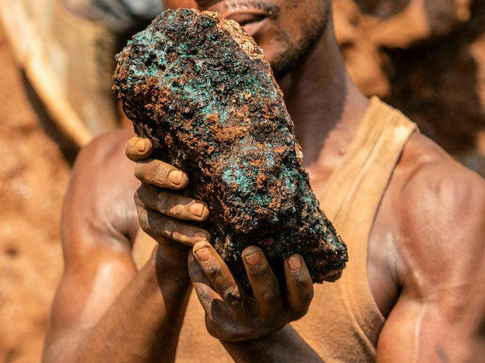 An artisanal miner holds a cobalt stone at the Shabara artisanal mine in the DRC.