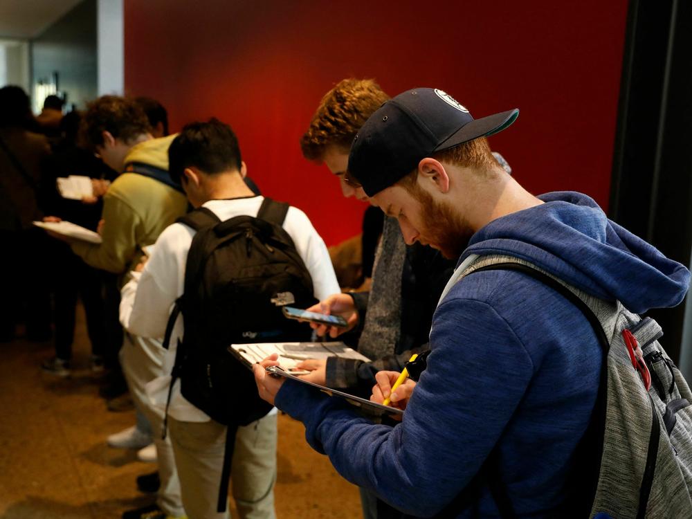 A young man fills out an application to cast his ballot at the Ann Arbor clerk's satellite office on the University of Michigan campus.