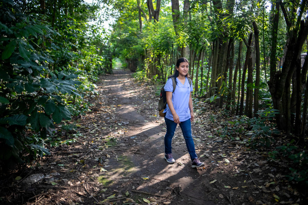 Neudy Rojop directs a research study that uses mosquitoes like a swarm of flying syringes to sample the blood of people and animals in nearby communities. Here, she walks to one of the homes enrolled in the study.