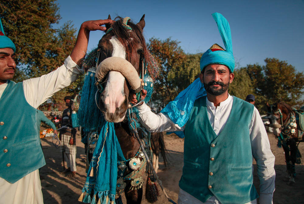 Chaudry Zahoor, 25, left, poses near his horse after his team, the Husna Punjab Tent Pegging Club, won two rounds. Zahoor is from a landowning family who own a Belorusian tractor to harvest their cash crop, sugar cane.