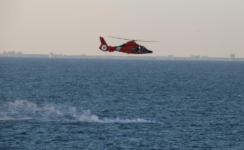 A U.S. Coast Guard helicopter flies over a debris field on Saturday during recovery efforts for the high-altitude surveillance balloon.