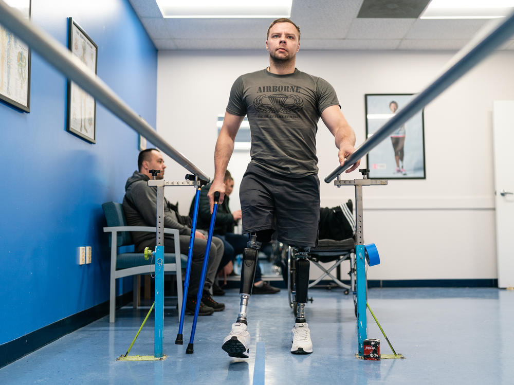 Oleksandr Fedun, 24, holds onto railings as he practices walking on his prostheses at Medical Center Orthotics & Prosthetics (MCOP) in Silver Spring, Md., on Thursday. MCOP is working with several charities and organizations to help fit Ukrainian soldiers with prostheses after they've been injured in combat.