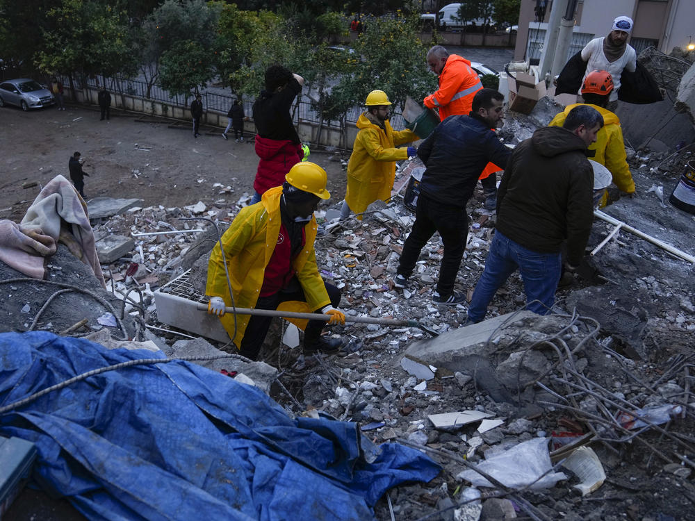 Emergency team members search for people in a destroyed building in Adana, Turkey on Monday.