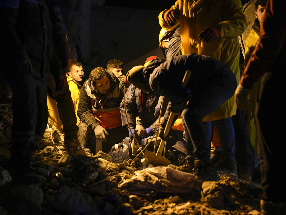 Emergency teams search in the rubble for people in a destroyed building in Adana, Turkey, on Monday.