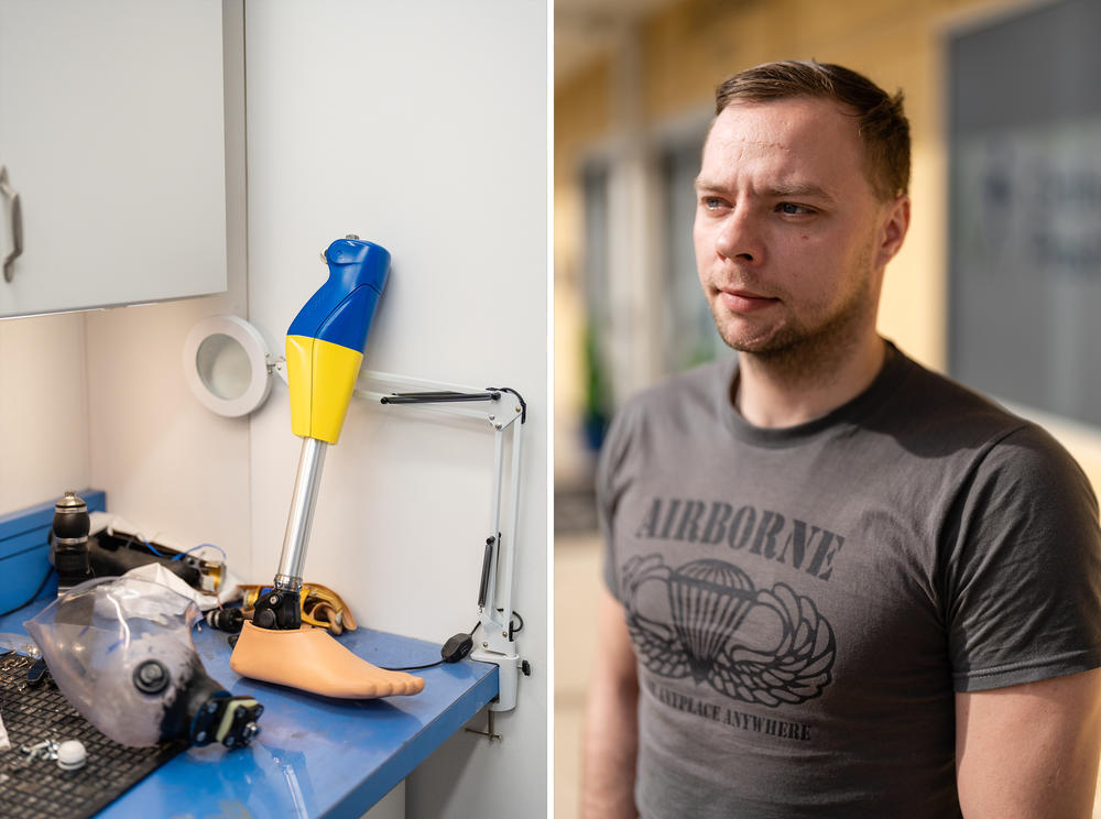 Oleksandr Fedun stands next to a prosthesis designed with the colors of the flag of Ukraine in the workshop.
