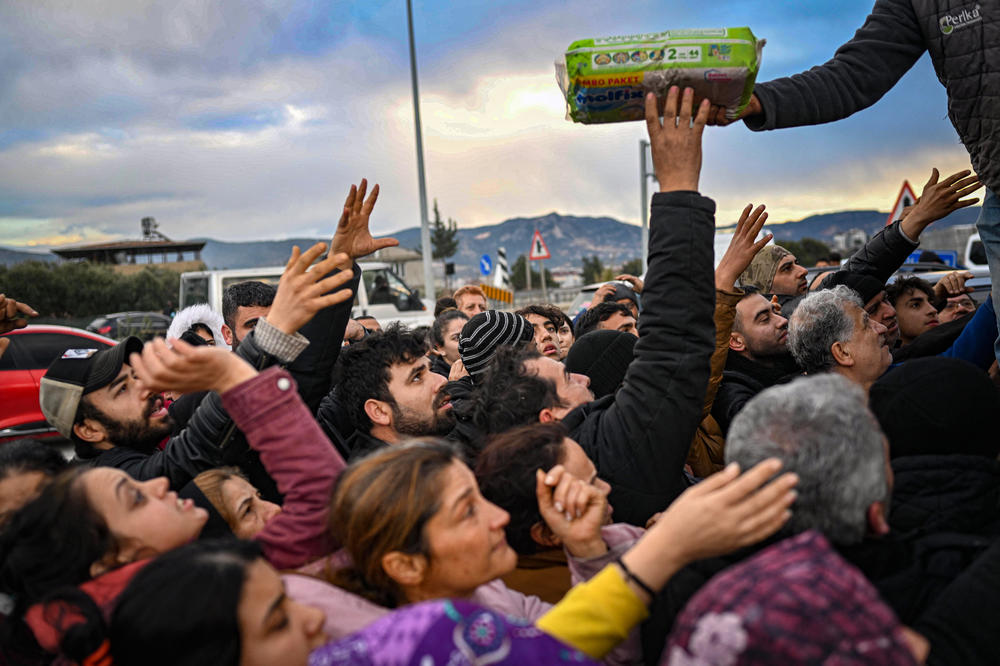 Earthquake survivors gather at a diaper distribution in Hatay, Turkey, on Feb. 7, a day after a 7.8-magnitude earthquake struck the country's southeast.