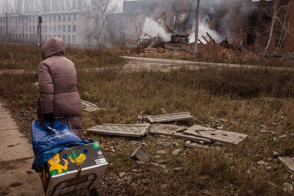 Upon entering Bakhmut, a steaming crater from a rocket strike filled the sky with smoke as bundled, grim civilians occasionally walked by mostly searching for food or medicine or carrying supplies.