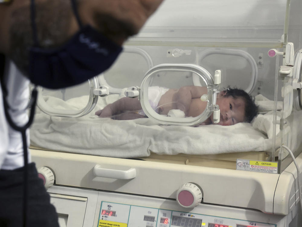 A baby girl who was born under the rubble caused by an earthquake that hit Syria and Turkey receives treatment inside an incubator at a children's hospital in the town of Afrin in Syria's Aleppo province on Tuesday. Residents in a northwest Syrian town discovered a crying infant whose mother gave birth to her while buried underneath the rubble of a five-story apartment building.