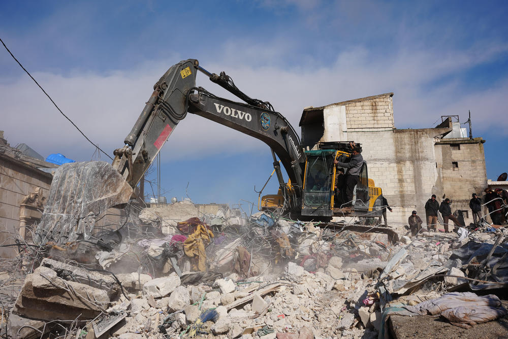 People search the rubble of a house in which one entire family except a newborn baby was killed, in the town of Jandaris, in the rebel-held part of Aleppo province, Syria following a deadly earthquake on Tuesday.