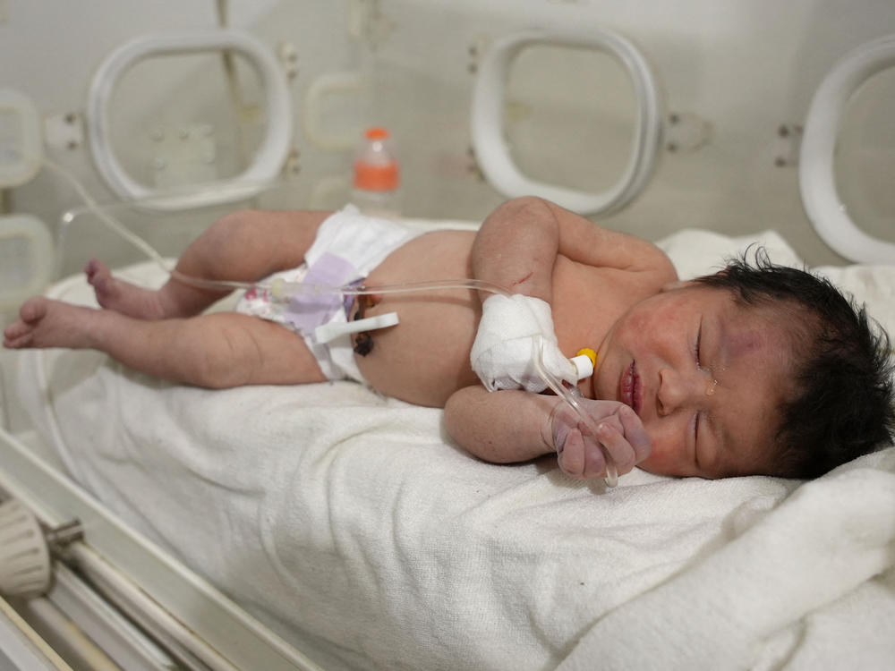 A newborn baby who was found still tied by her umbilical cord to her mother and pulled alive from the rubble of a home in northern Syria following a deadly earthquake, receives medical care at a clinic in Afrin, on Tuesday. The infant is the sole survivor of her immediate family, the rest of whom were killed when the quake flattened their home in Jindayris, cousin Khalil al-Suwadi said.
