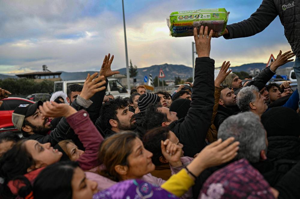 Earthquake survivors gather to collect supplies at a diaper distribution in Hatay, Turkey, on Tuesday, a day after a 7.8 magnitude earthquake struck the country's southeast.