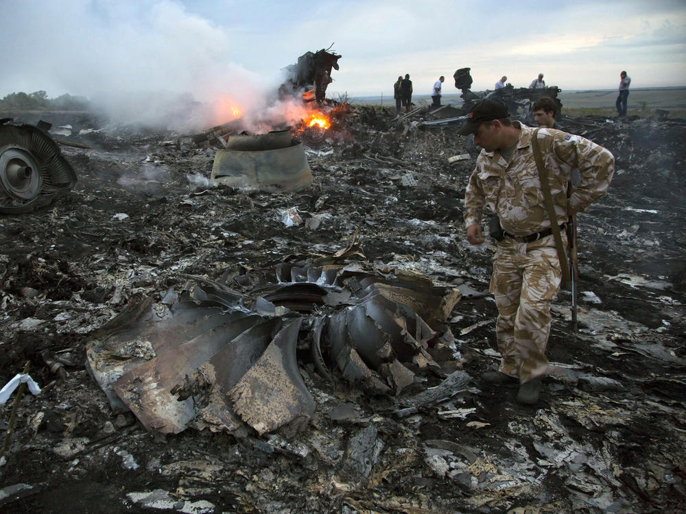 People walk among the debris at the crash site of Malaysia Airlines flight MH17 near the village of Grabovo, Ukraine, on July 17, 2014. All 298 people on board were killed.
