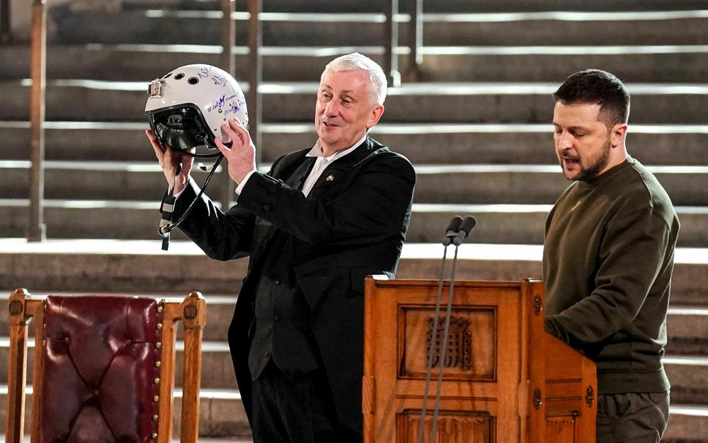 Speaker of the House of Commons Lindsay Hoyle (left) holds the helmet of a Ukrainian pilot, inscribed with the words 