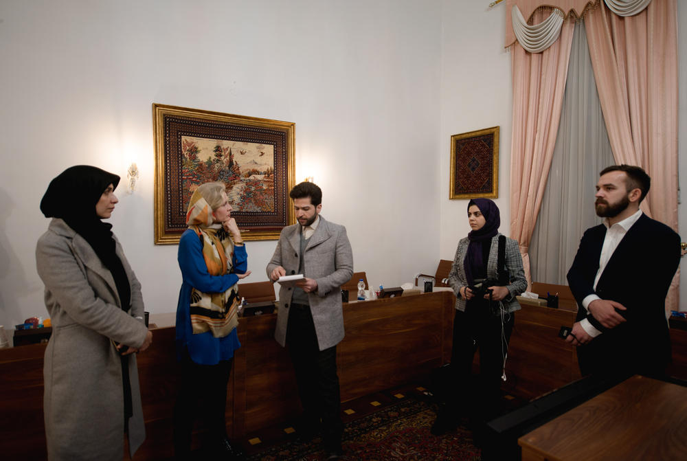 The NPR team — Mary Louise Kelly (second from left), and (right) Fatma Tanis and Connor Donevan — prepare for the interview.