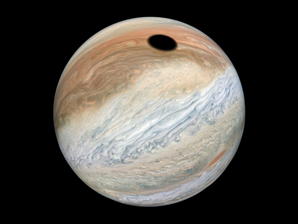 This composite was made with images from NASA's Juno mission and shows the shadow on Jupiter cast by Io, one of its many moons.