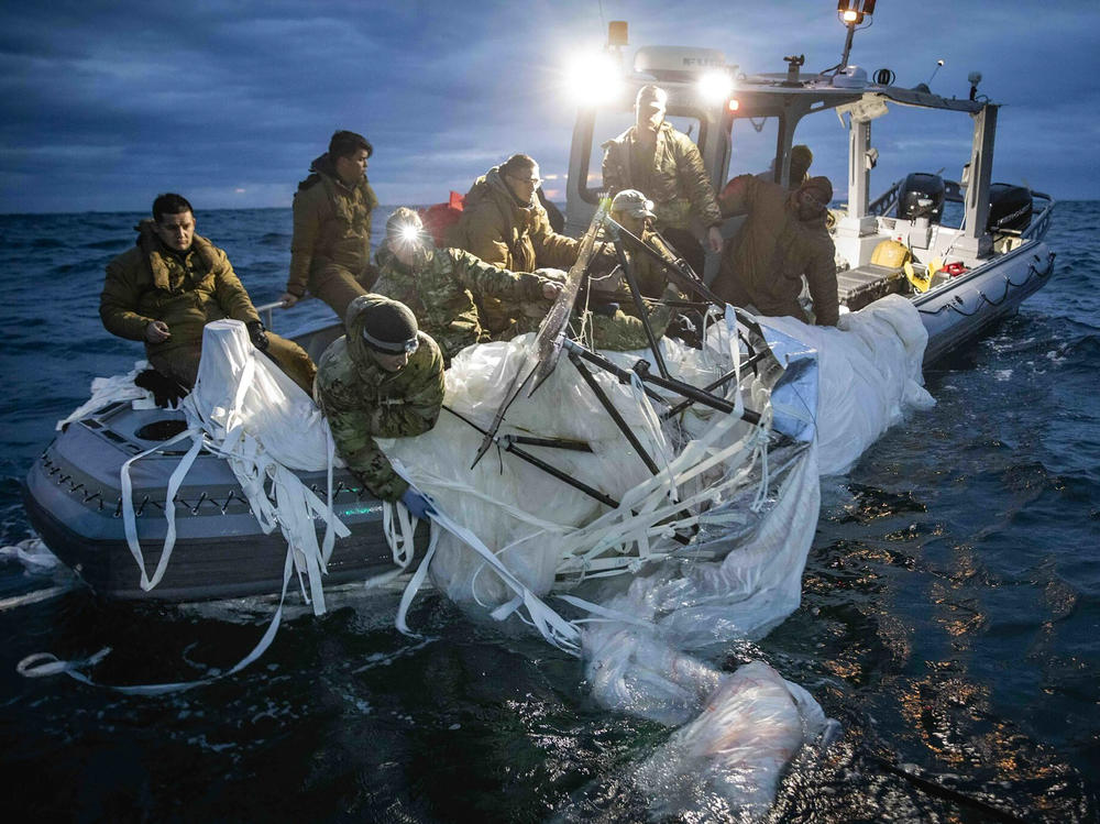 This image provided by the U.S. Navy shows sailors assigned to Explosive Ordnance Disposal Group 2, recovering a high-altitude surveillance balloon off the coast of Myrtle Beach, S.C., on Sunday.