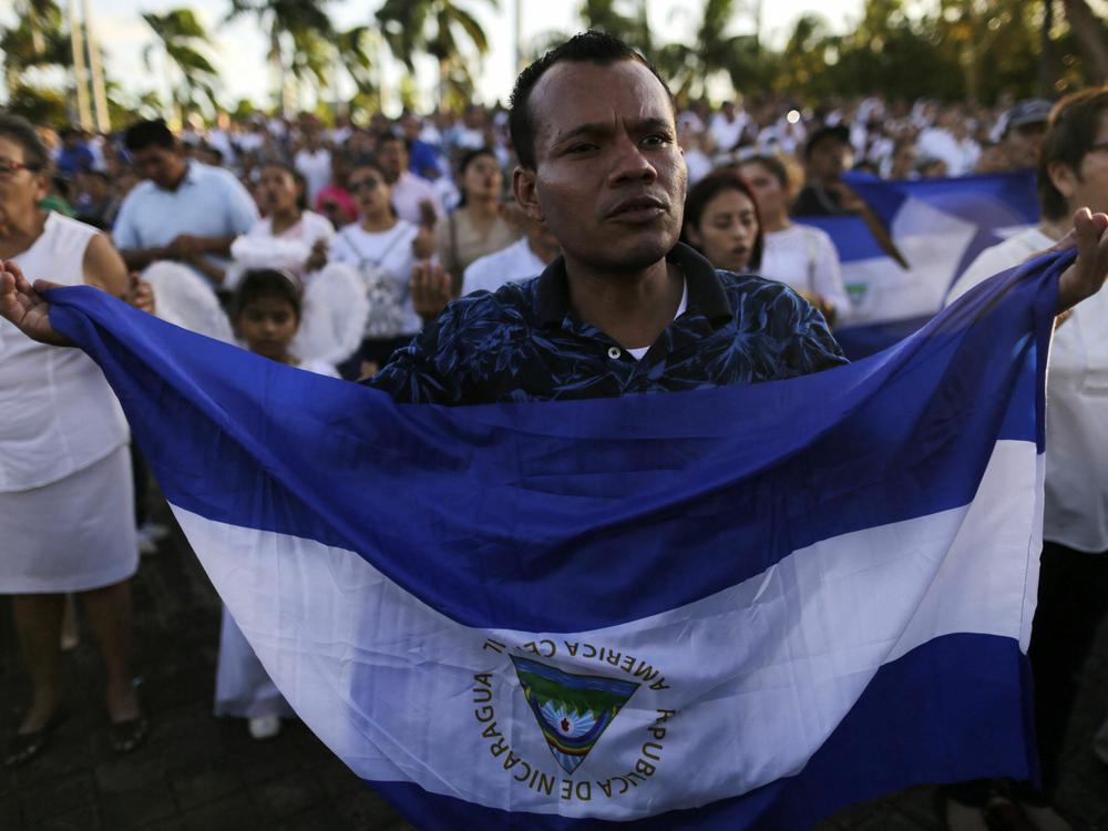 A man holds a Nicaraguan flag in favor of peace in Nicaragua.